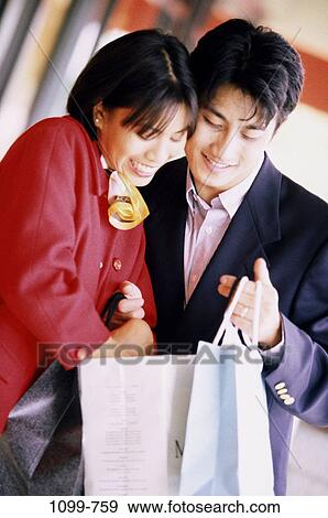 Stock Photo - people, smiling, suit, Asian, couple, outdoors, bag. Fotosearch