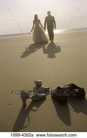 Stock Image - people, walking, couple, beach, shoes, romantic, shore. Fotosearch