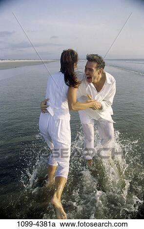 people, water, playing, couple, spraying, beach, laughing View Large Photo Image Stock Image - people, water, playing, couple, spraying, beach, laughing. Fotosearch