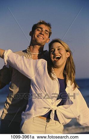 people, water, smiling, couple, beach, stretching, arms View Large Photo Image Stock Image - people, water, smiling, couple, beach, stretching, arms. Fotosearch