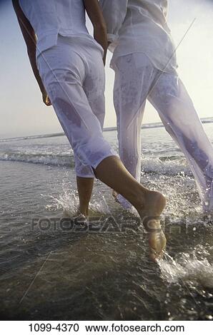 people, water, walking, couple, beach, splash, waves View Large Photo Image Stock Image - people, water, walking, couple, beach, splash, waves. Fotosearch