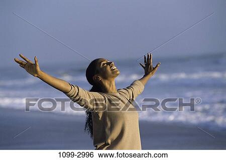 Stock Photograph - people, woman, smiling, success, beach, stretching. Fotosearch
