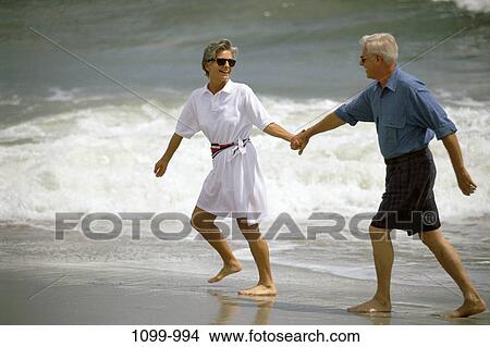 Picture - sand, people, hands, smiling, playing, walking, couple. Fotosearch