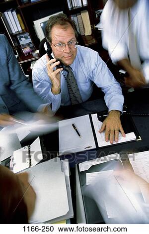 Stock Image - desk, telephone, paperwork, busy, phone, stress, business. Fotosearch