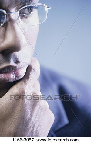 Stock Photo - eyeglasses, business, contemplation, serious, contemplating, thinking. Fotosearch