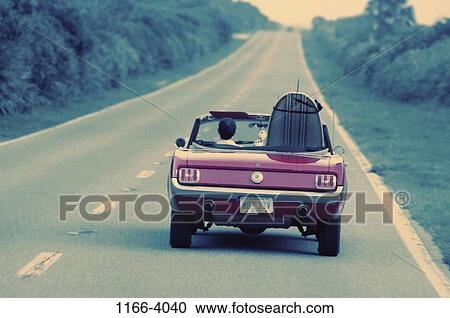 Stock Image - grass, people, road, car, driving, convertible. Fotosearch
