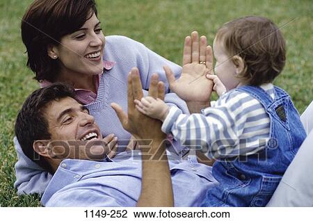Stock Image - grass, people, smiling, playing, clapping, sitting. Fotosearch
