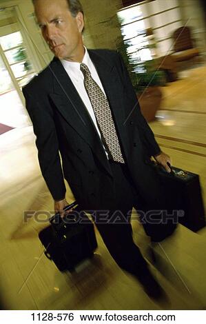 Stock Photograph - hotel, walking, briefcase, suit, luggage, motion. Fotosearch