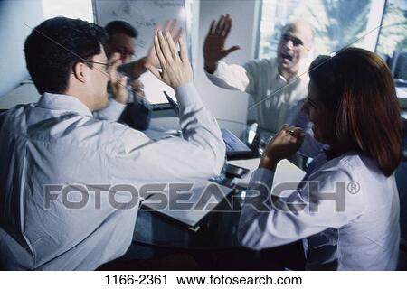 Stock Image - meeting, multiethnic, celebration, excited, business, Middle-aged, teamwork. Fotosearch