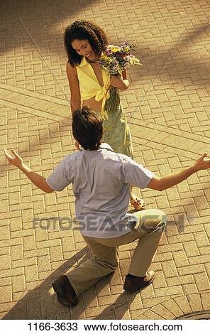 Stock Image - multiethnic, people, couple, flowers, outdoors, romantic, romance. Fotosearch