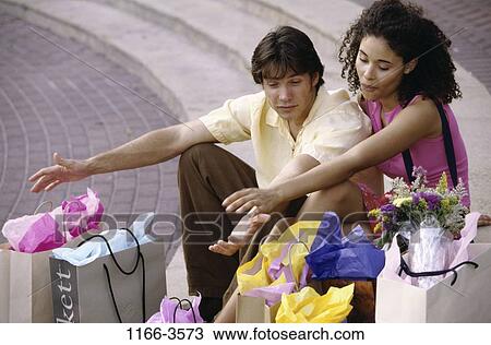 Stock Image - multiethnic, people, couple, outdoors, shopping, shop, shopping bags. Fotosearch