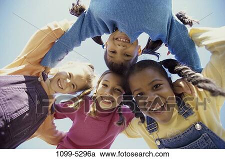 Stock Image - multiethnic, people, smiling, circling, playing, friendship, outdoors. Fotosearch