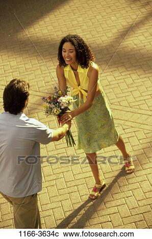 Stock Image - multiethnic, people, smiling, couple, flowers, outdoors, smile. Fotosearch