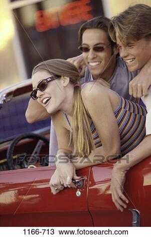 Stock Image - multiethnic, people, smiling, talking, car, convertible, laughing. Fotosearch