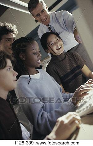 Stock Photo - multiethnic, people, teacher, school, computer, typing, classroom. Fotosearch