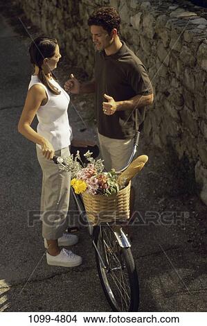 people, couple, conversation, bicycle, flowers, flirting, gesturing View Large Photo Image Picture - people, couple, conversation, bicycle, flowers, flirting, gesturing. Fotosearch