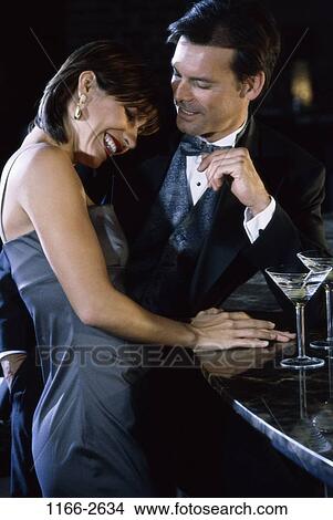 Picture - people, couple, drinking, laughing, leaning, standing, bar. Fotosearch