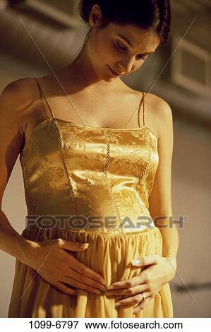 Stock Photo - people, gold, woman, dress, down, looking, contemplation. Fotosearch