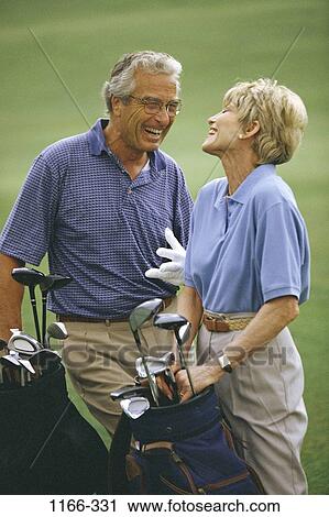 Stock Image - people, green, playing, golf, couple, senior, laughing. Fotosearch
