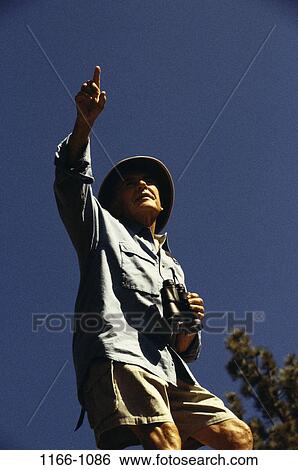 people, hat, binoculars, senior, pointing, outdoors View Large Photo Image Stock Photograph - people, hat, binoculars, senior, pointing, outdoors. Fotosearch