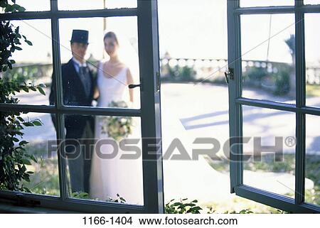 Picture - people, hat, couple, window, standing, outdoors, commitment. Fotosearch