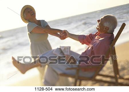 people, hat, newspaper, couple, senior, reading, beach View Large Photo Image Picture - people, hat, newspaper, couple, senior, reading, beach. Fotosearch