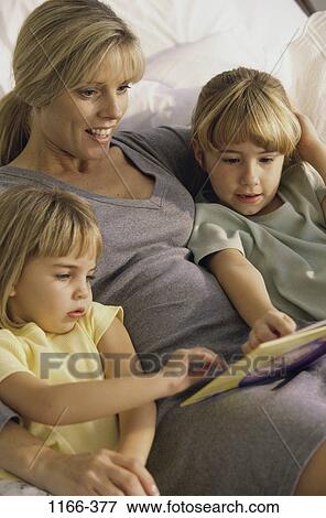 Stock Photo - people, mother, reading, family, blond, close, daughters. Fotosearch