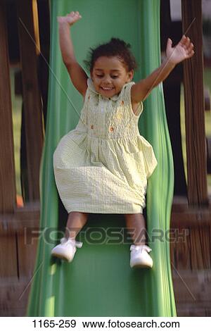 Stock Photo - people, playing, billowing, girl, dress, sliding, playground. Fotosearch