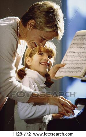 Stock Image - people, playing, mother, music, piano, accuracy, teamwork. Fotosearch