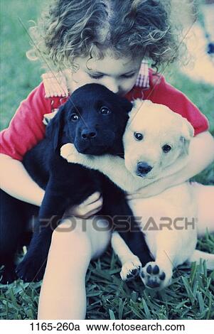 Stock Image - people, playing, puppies, sitting, pets, girl, outdoors. Fotosearch