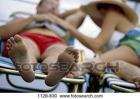 Stock Image - people, pool, hat, couple, reading, outdoors, relaxing. Fotosearch