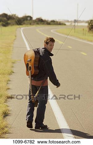 Stock Image - people, road, guitar, outdoors, jacket, jeans. Fotosearch