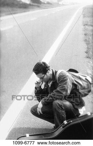 Stock Photo - people, road, smoke, cigarette, backpack, guitar. Fotosearch