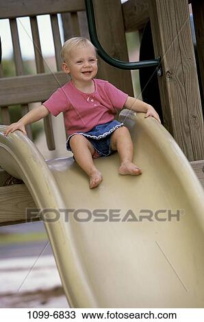 Stock Image - people, smiling, playing, sitting, girl, sliding, playground. Fotosearch