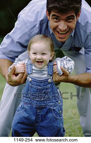 Picture - people, smiling, walking, laughing, toddler, holding, outdoors. Fotosearch
