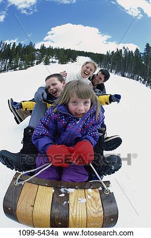 Stock Image - people, snow, playing, winter, laughing, hill, outdoors. Fotosearch