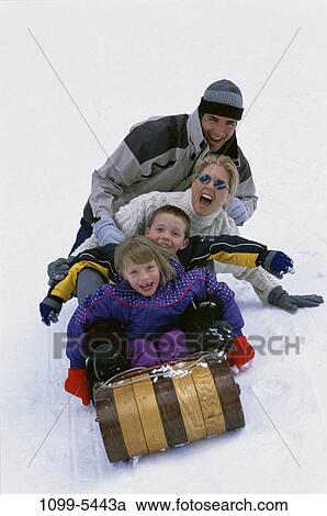 Stock Image - people, snow, playing, winter, laughing, sunglasses, hill. Fotosearch