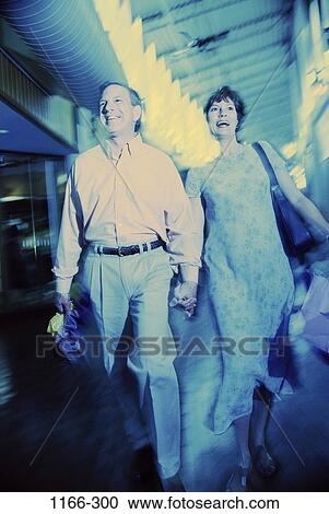 Stock Image - people, walking, couple, distorted, Middle-aged, shopping, mall. Fotosearch