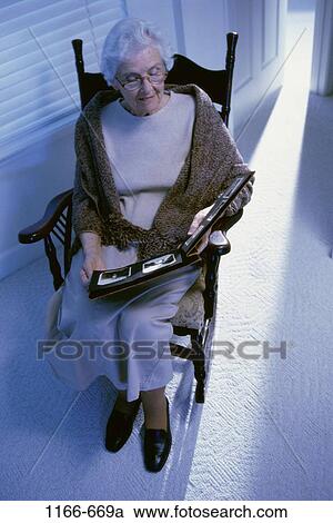 Stock Image - people, woman, eyeglasses, senior, indoors, rocking chair. Fotosearch