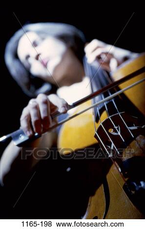 Stock Photo - people, woman, playing, entertainment, play, brunette, bow. Fotosearch