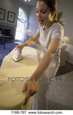 Stock Photo - people, woman, shouting, iron, surprise, brunette. Fotosearch