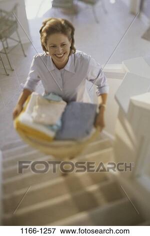 Stock Photo - people, woman, smiling, climbing, bright, smile, laundry. Fotosearch