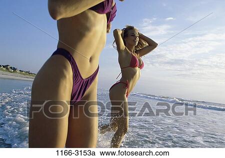 Stock Image - women, people, beach, splash, tranquility, splashing, friends. Fotosearch
