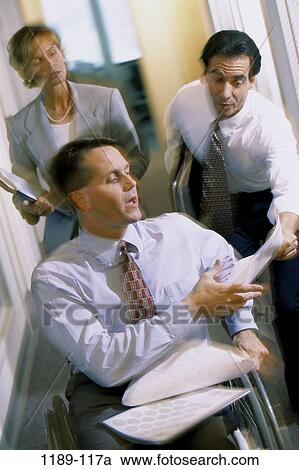 Stock Image - coworkers, paperwork, papers, wheelchair, stress, business, chaotic. Fotosearch