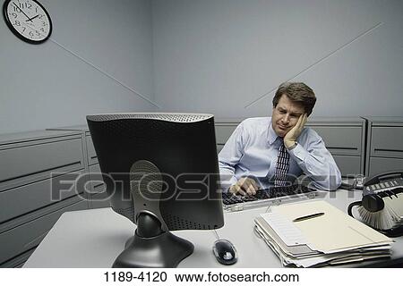 Stock Image - desk, computer, typing, worker, business, Middle-aged. Fotosearch