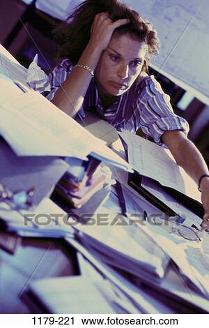 Stock Image - desk, woman, paperwork, overwhelmed, stress, business, defeat. Fotosearch