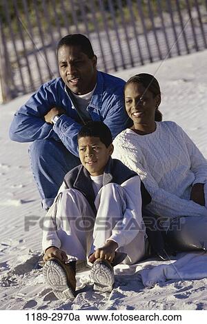 Stock Image - fence, sand, people, sitting, beach, family. Fotosearch
