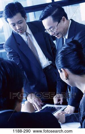 Stock Image - groups, smiling, Asian, pointing, leaning, business, achievement. Fotosearch