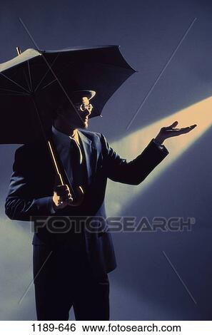 Stock Photograph - hand, light, umbrella, rain, business, outdoors. Fotosearch