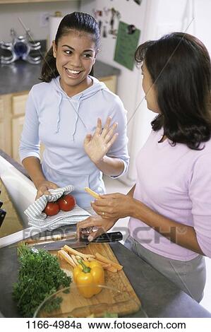 Stock Image - home, mother, Hispanic, healthy, cooking, knife, vegetables. Fotosearch